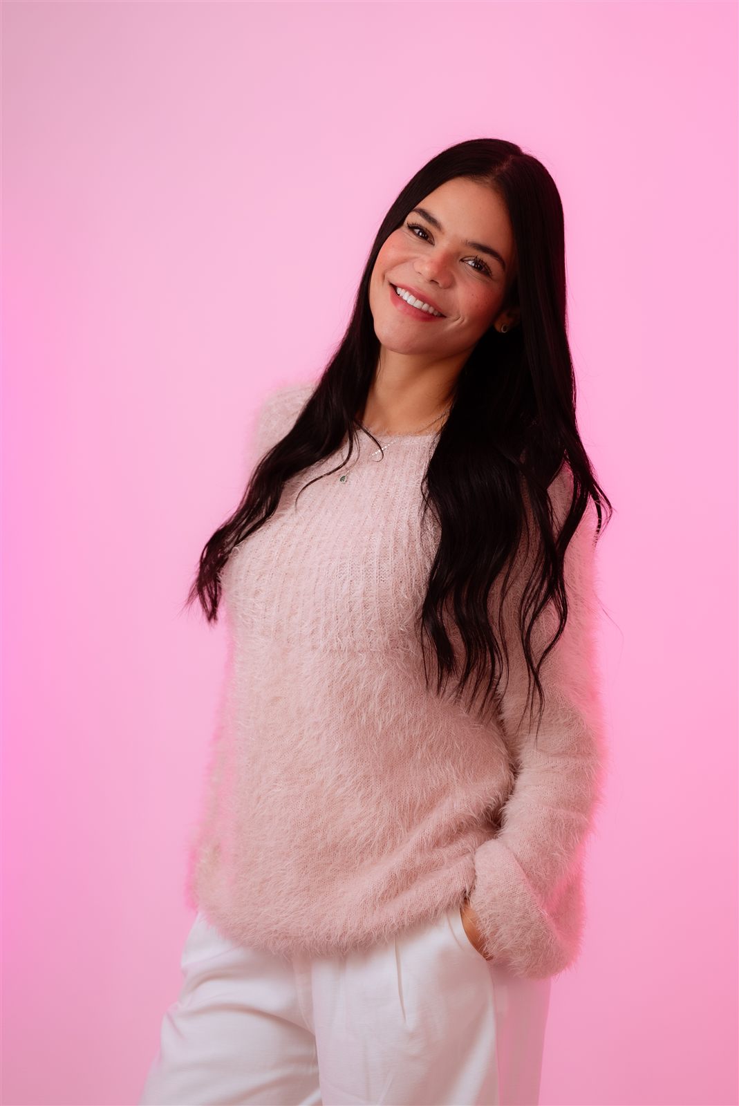 Diana Montoya sonriendo en un retrato profesional sobre fondo rosa